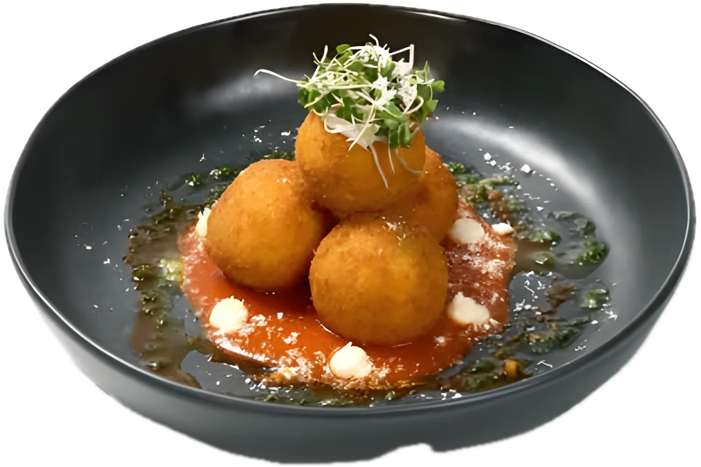 Beef Arancini: three crispy rice balls on tomato sauce with basil oil and microgreens, in a black bowl
